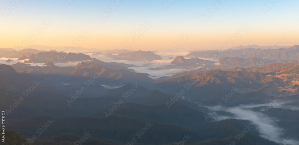Aerial top view of forest trees and green mountain hills with sea fog, mist and clouds. Nature landscape background, Thailand.