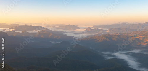 Aerial top view of forest trees and green mountain hills with sea fog, mist and clouds. Nature landscape background, Thailand. © tampatra