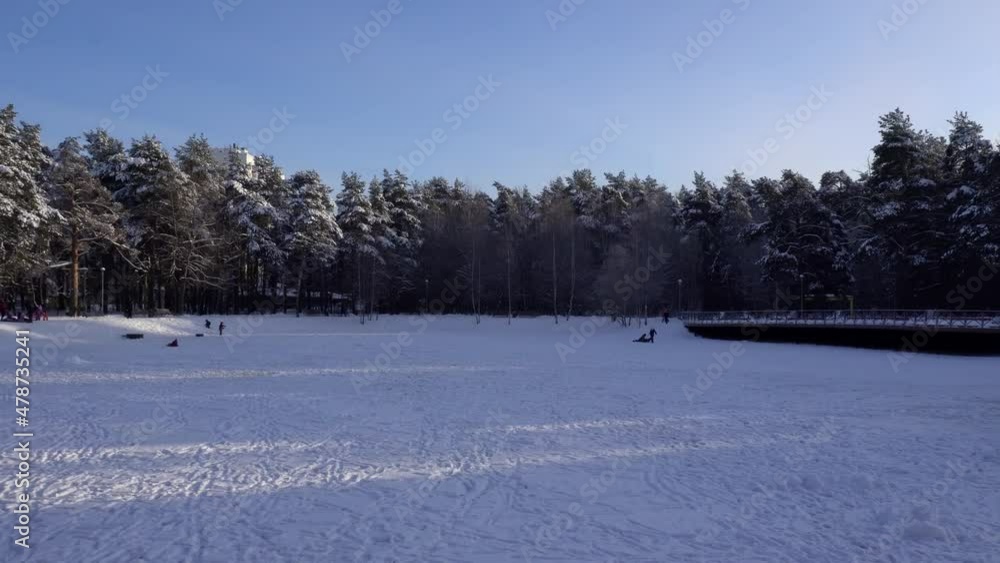 Winter recreational activities on the frozen snowy pond of city park. Moscow, Russia Winter recreational activities on the frozen snowy pond of city park. Moscow, Russia
