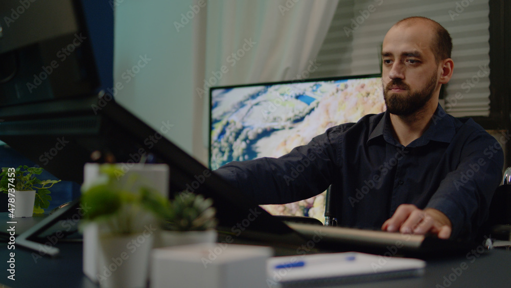 Fototapeta premium Photographer with disability doing retouch work on pictures for media production in workplace. Man working as editor retouching photos using touch screen monitor sitting in wheelchair