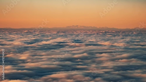Time lapse view of a cloud inversion at sunset viewed from the Col de Battaglia in the Balagne region of Corsica with the snow covered Alps in the distance