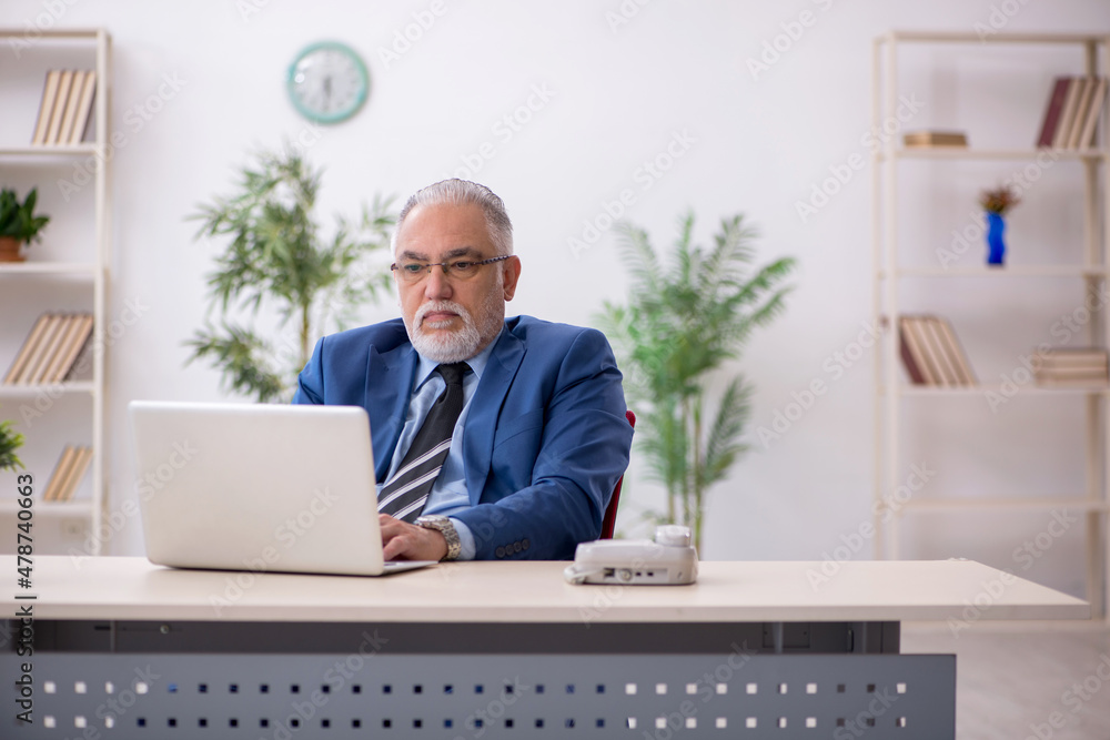 Aged businessman employee working at workplace Aged businessman employee working at workplace