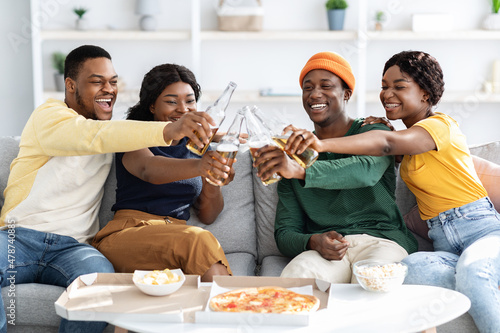 Joyfull african american millennial friends eating pizza