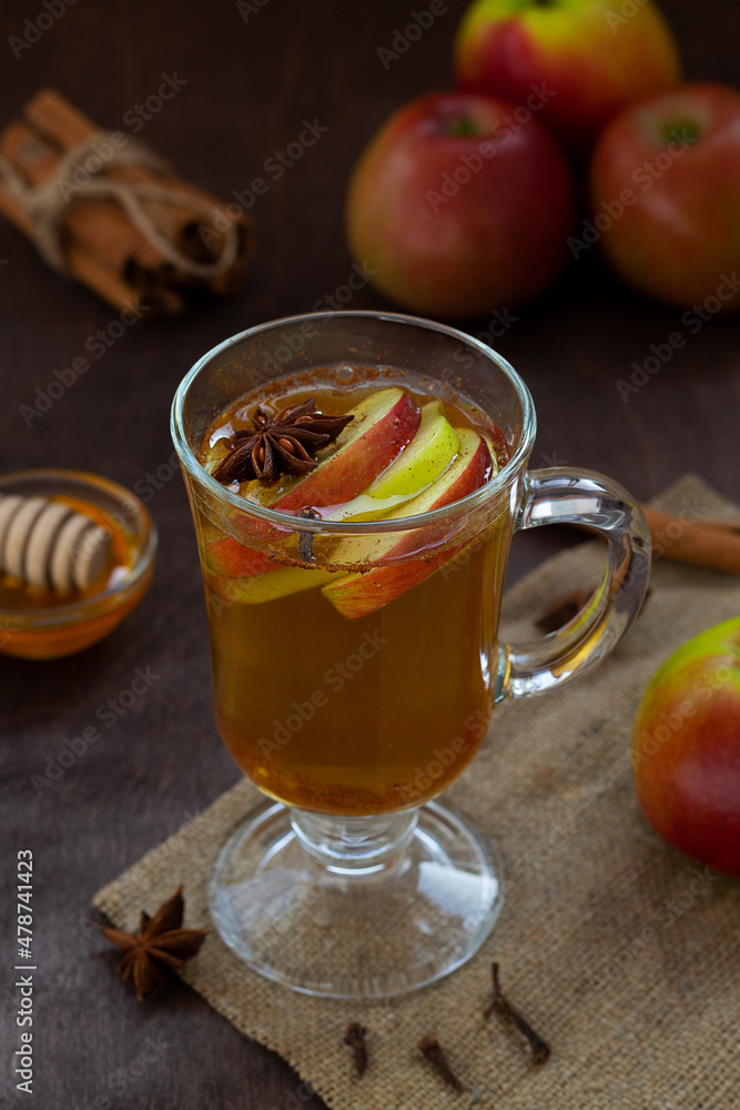 apple cider with fresh apples and honey. Hot fruit tea with spices: cinnamon, cardamon, anise, clove on the wooden table. Christmas drinks with sackcloth. mulled wine. vertical apple cider with fresh apples and honey. Hot fruit tea with spices: cinnamon, cardamon, anise, clove on the wooden table. Christmas drinks with sackcloth. mulled wine. vertical
