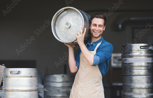 Fotografia Brewery, work in warehouse, modern strong worker brewer loads ingredients