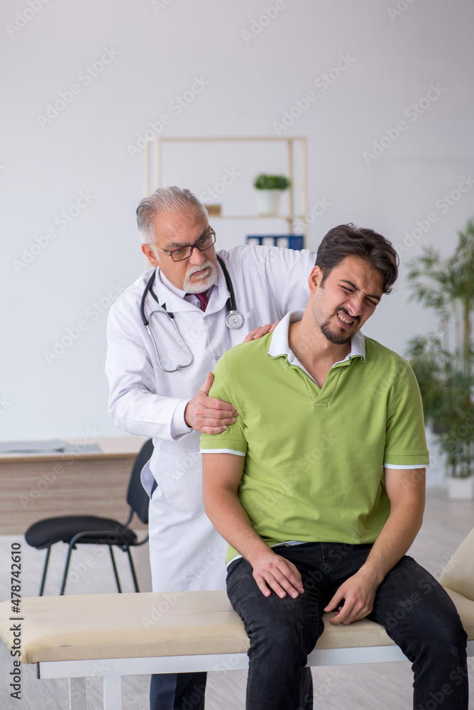 Obraz premium Young male patient visiting old male doctor