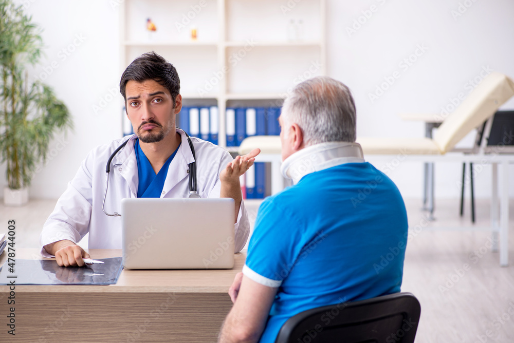 Old neck injured male patient visiting young male doctor Old neck injured male patient visiting young male doctor