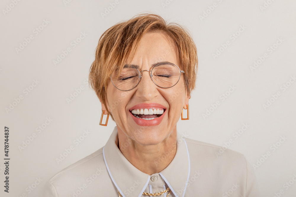  Middle-aged baby boomer woman smiles broadly with beautiful healthy teeth.