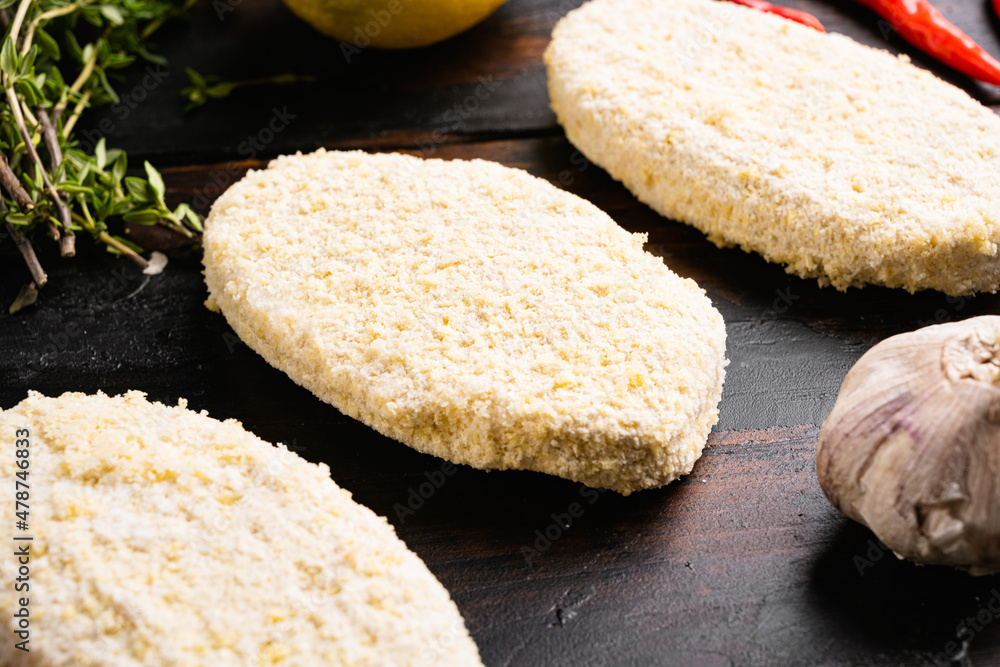 Uncooked Raw breaded patty cutlets, on old dark  wooden table background