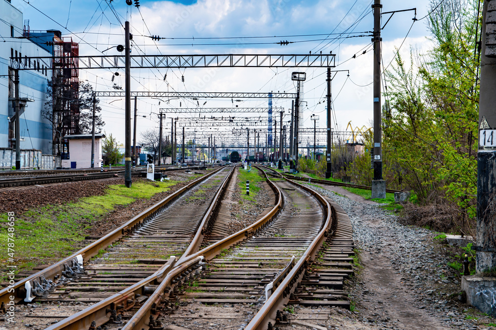 Railroad tracks with rails and electric power wires for trains. Rails and sleepers. High-voltage supply voltage wires. Railway equipment. Trains and locomotives. Direction of movement. Railroad tracks with rails and electric power wires for trains. Rails and sleepers. High-voltage supply voltage wires. Railway equipment. Trains and locomotives. Direction of movement.