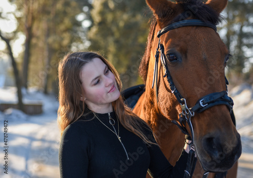 Young girl with horse on winter forest road © AliaksandrBS