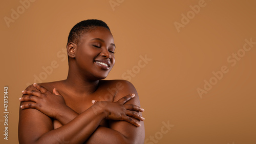 Beautiful plus size African american woman embracing herself