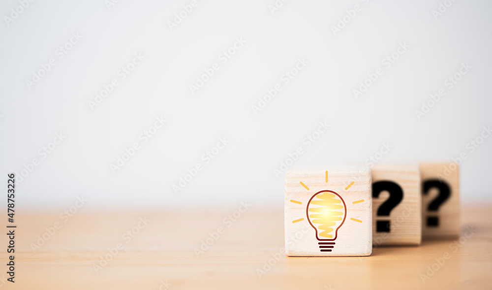 Drawing glowing lightbulb in front of question mark which print on wooden cube block for question answer and problem solving solution concept. Drawing glowing lightbulb in front of question mark which print on wooden cube block for question answer and problem solving solution concept.