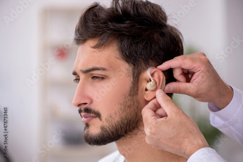 Young male patient with hearing problem visiting old doctor otor