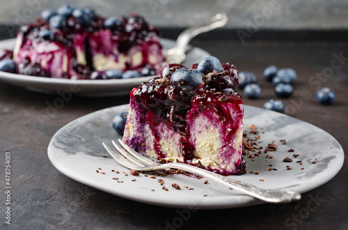 Traditional blueberry cheesecake with fresh berries, compote and chocolate crumbles served as close-up on a design plate photo