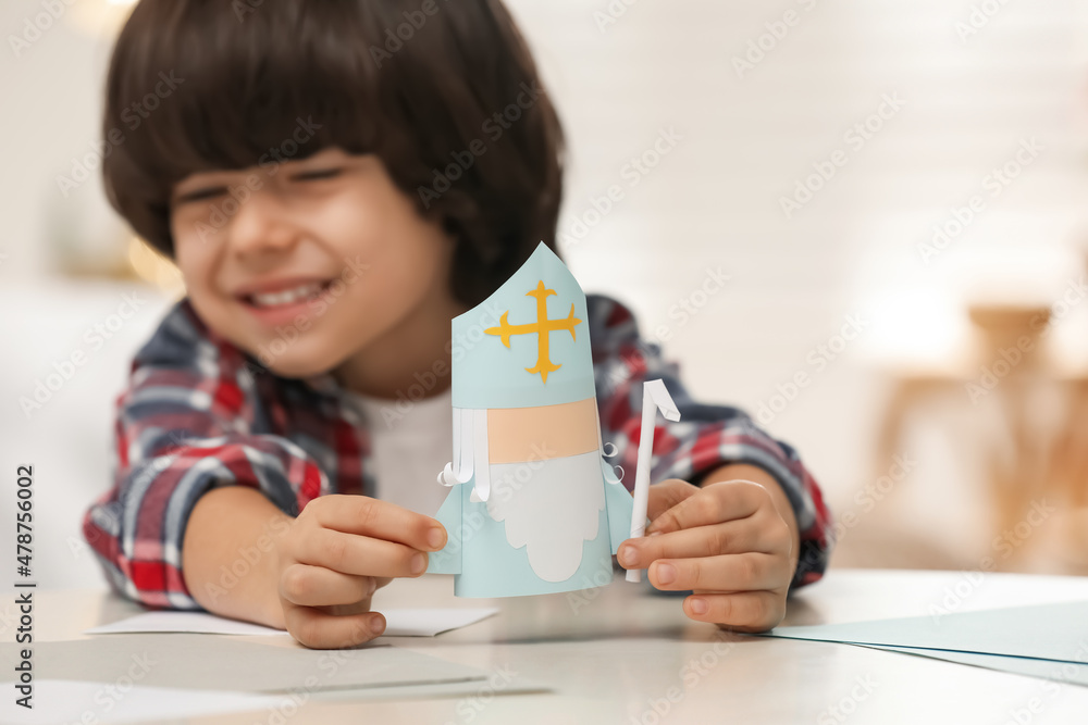 Cute little boy with paper Saint Nicholas toy at home, focus on hands Cute little boy with paper Saint Nicholas toy at home, focus on hands