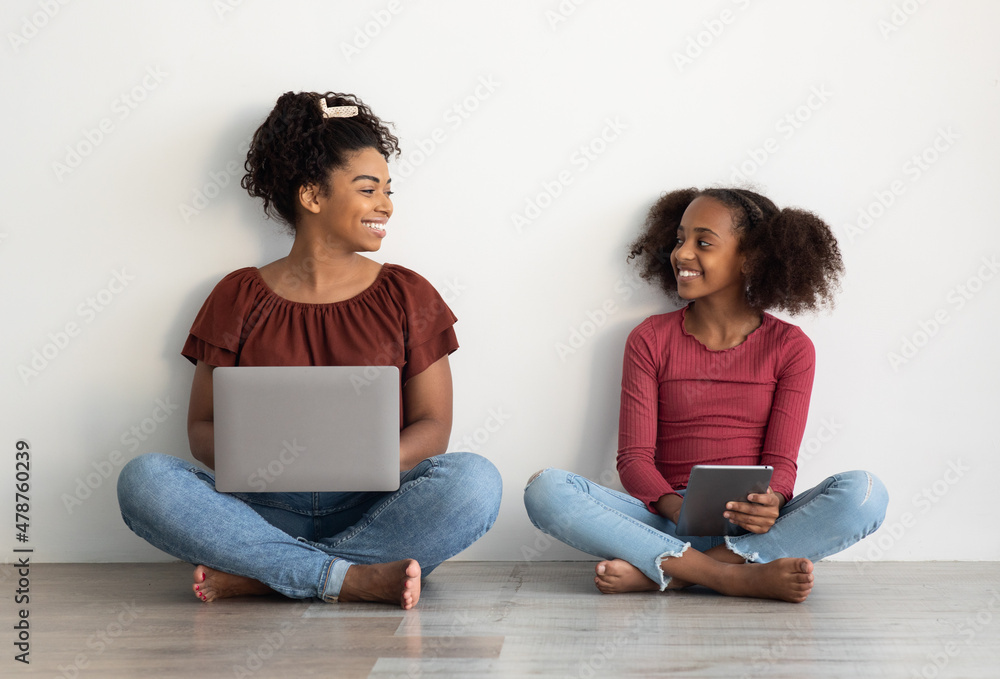 Happy black mom and teen kid using gadgets Happy black mom and teen kid using gadgets