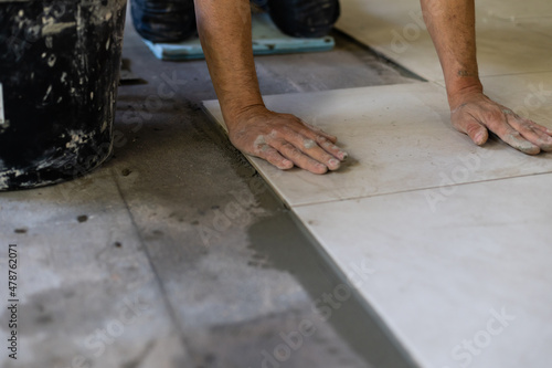 Builder puts the tiles on the floor, the repair