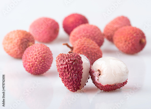 Peeled lychees and peeled lychees, isolated on a white background. Blurred background.