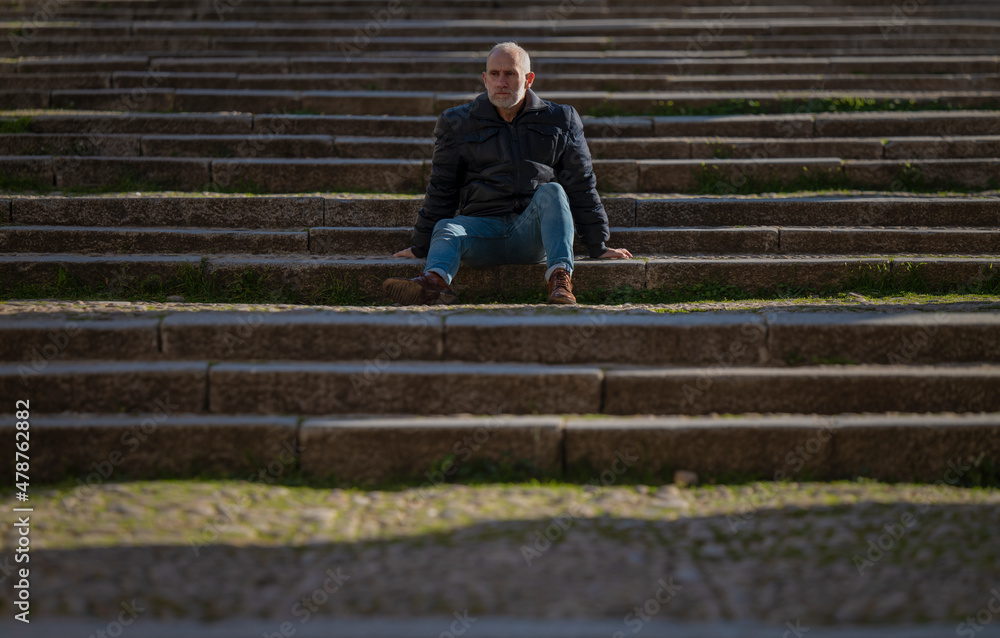 Adult man sitting on stairway. Segovia, Spain