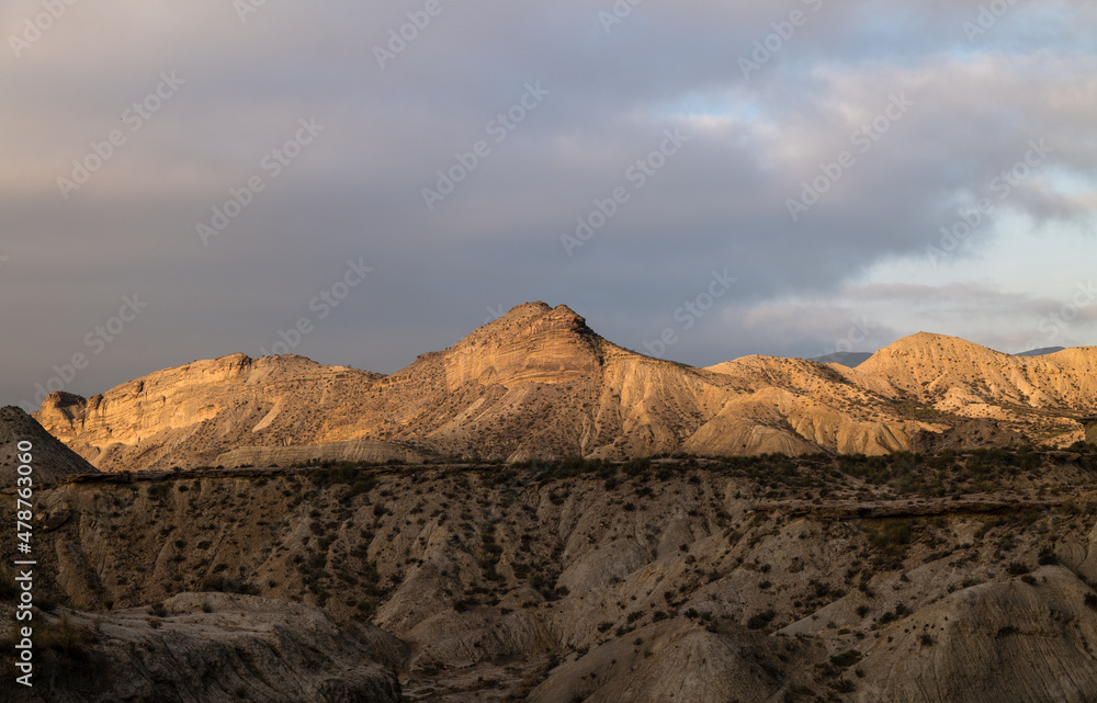 Landscape of Tabernas Desert, Almeria, Spain, in the morning with sunlight and shadow, against cloudy sky