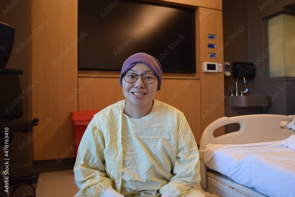 Young Female Adult in Hospital Gown Smiling No Hair