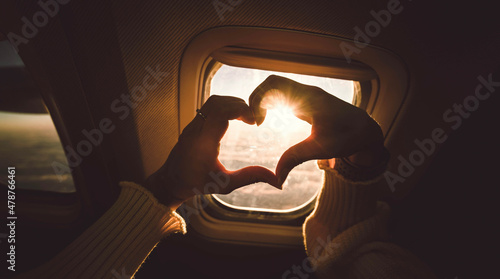 Obraz na płótnie Tourist woman making heart shape with hands in airplane - Travel addicted concep