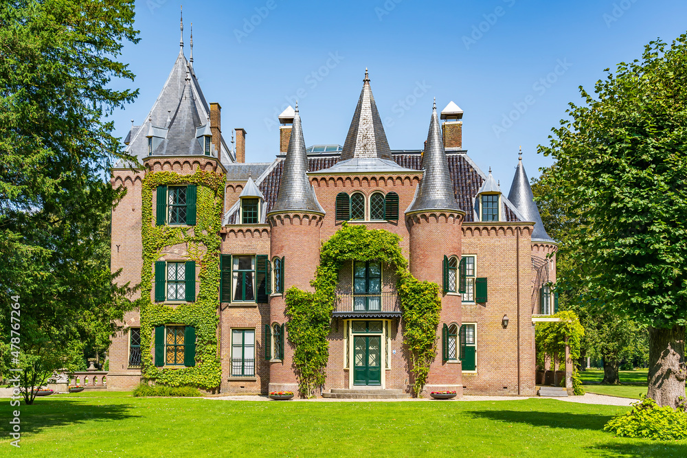 The side view of a castle, partly overgrown with beautiful ivy, in a park in Lisse, the Netherlands