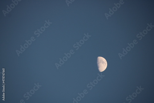 white half moon in blue sky