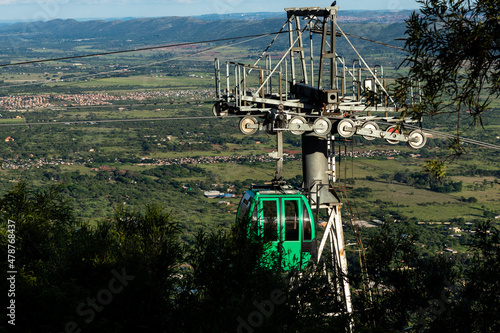 Empty green cable car going up Magaliesberg Mountain Range near Hartbeespoort Dam, South Africa photo