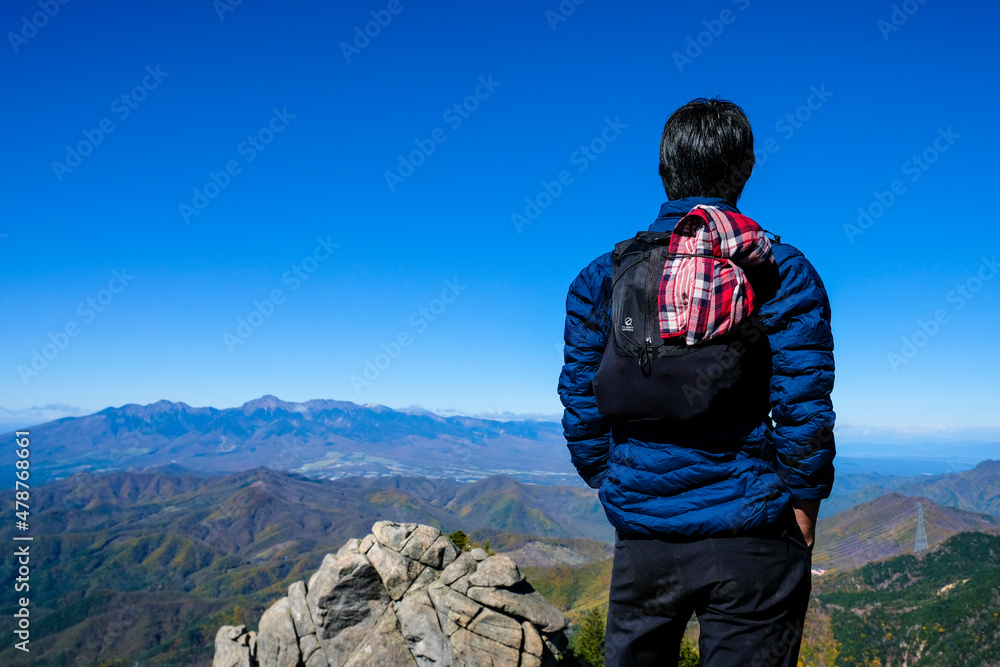 遠くの山々を眺める男性
