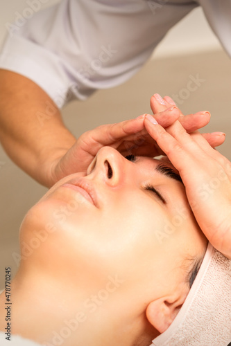 Beautiful young caucasian woman receiving a head massage in a beauty clinic, close up