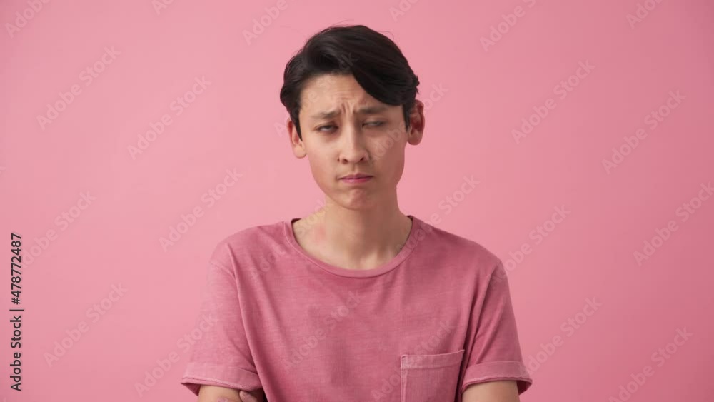 Bored Asian man looking around in the pink studio Bored Asian man looking around in the pink studio