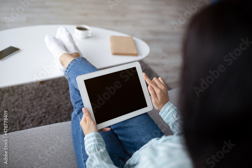 Unrecognizable Indian woman using tablet with empty screen at home, mockup for app or website
