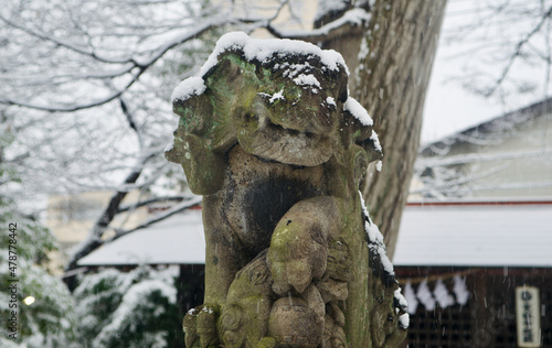 Photography stone guardian in a shinto shrine covered in snow
