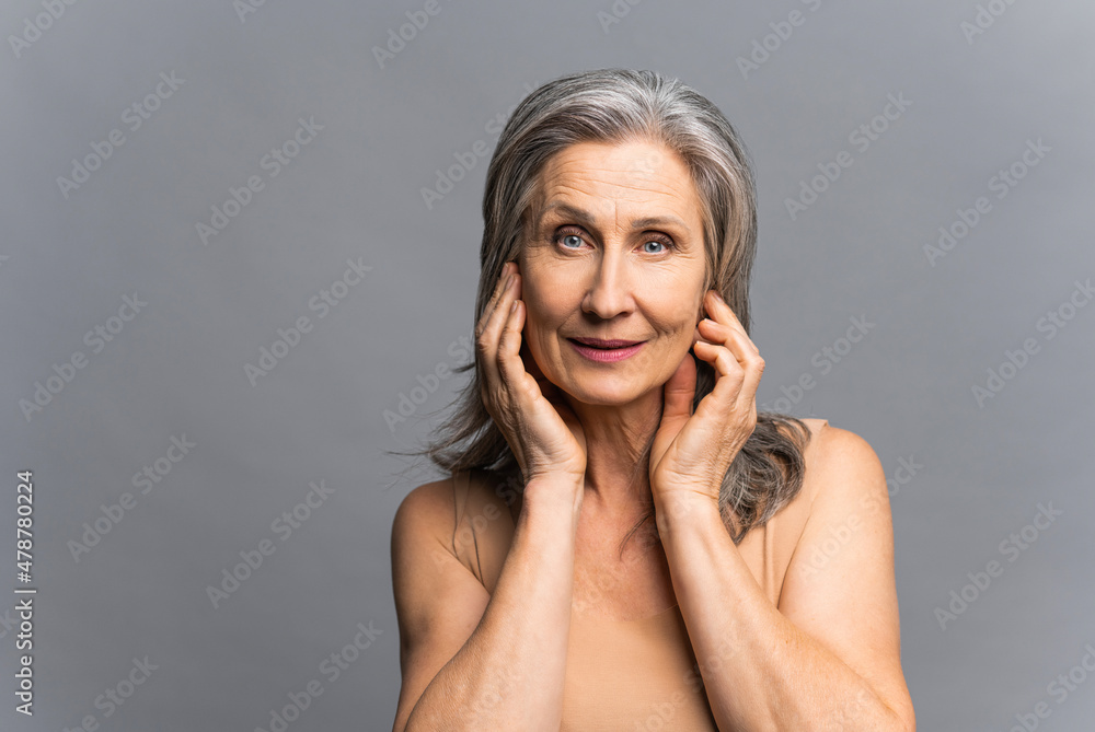 Φωτογραφία Beautiful mature gray-haired woman with fresh pure healthy skin holding face with hand palms with natural manicure