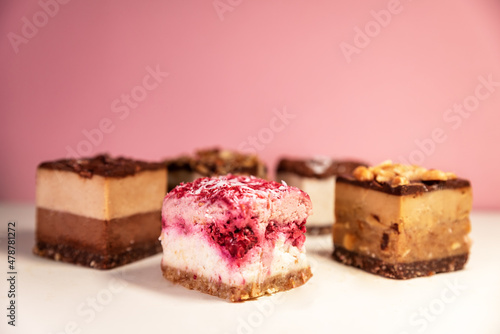 Various delicious vegan cakes on pink background
