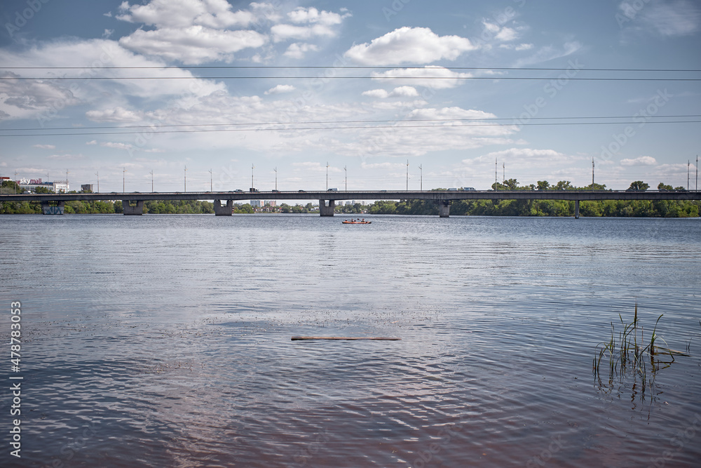 Scenic tranquil summer view on river Dnepr, clouds and bridge. Natural background