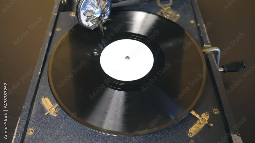 Top view on old playing gramophone. Needle sliding smoothly on black vinyl record spinning at vintage turntable. Retro concept. Slow motion Close up Top view on old playing gramophone. Needle sliding smoothly on black vinyl record spinning at vintage turntable. Retro concept. Slow motion Close up