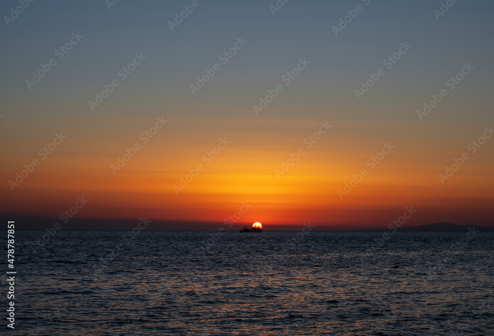 Silhouette of boat on sea beach with sunset background. Sunset moment at the sea side in Neos Marmaras, Greece.