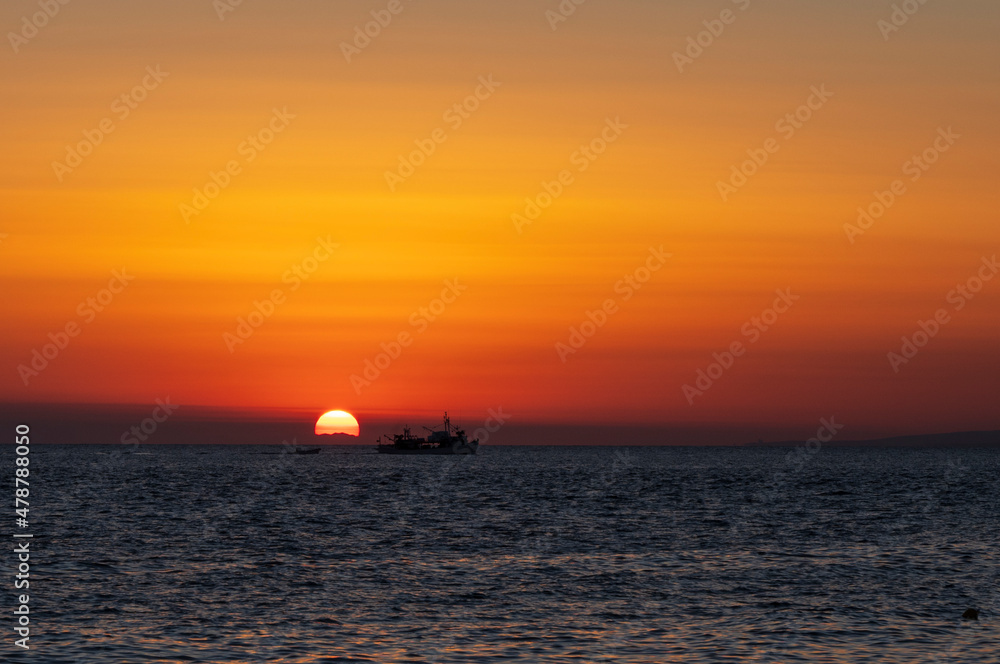Silhouette of boat on sea beach with sunset background. Sunset moment at the sea side in Neos Marmaras, Greece.