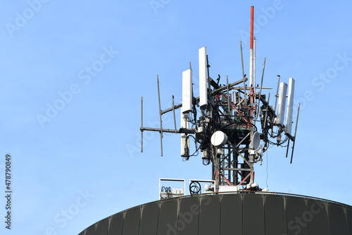 Detail of the telecommunication tower on the roof of a palace with blue sky. Telecommunication tower with antennas and antennas for microwaves, 4g radio links and distribution of the 5g generation photo