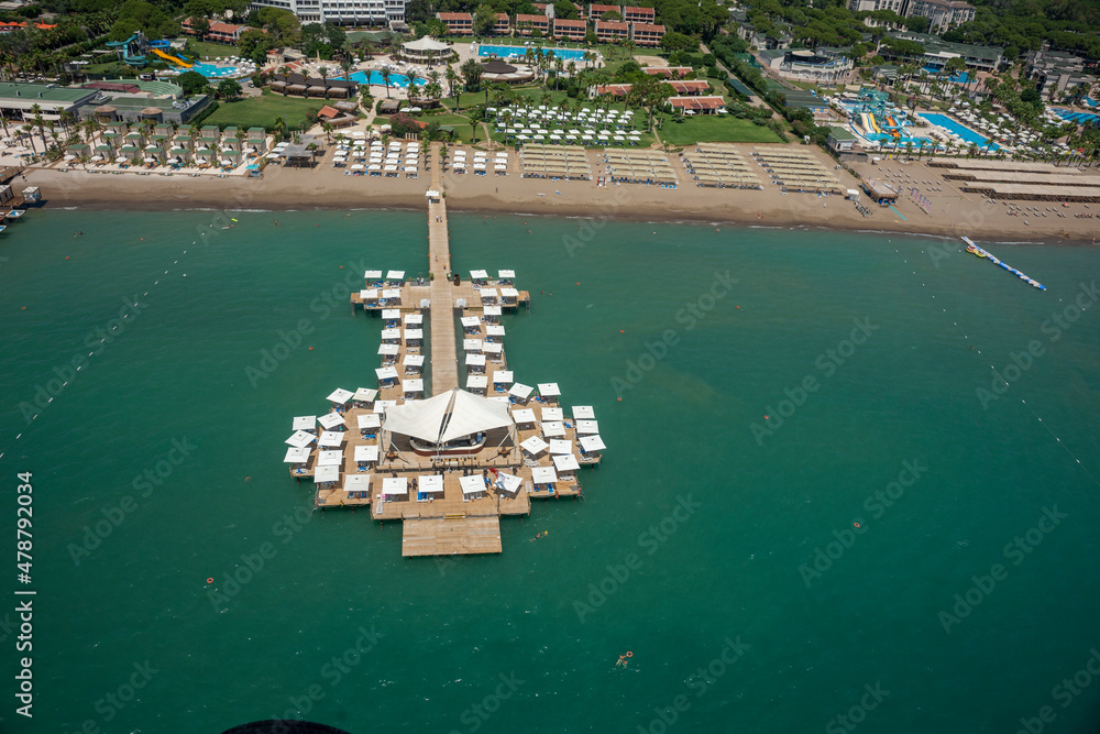 vacation,sea,coast,sand,hotel,structure,building,pier,blue,travel,tourism,sightseeing,leisure,boat,yacht,jet-ski,paraglider,