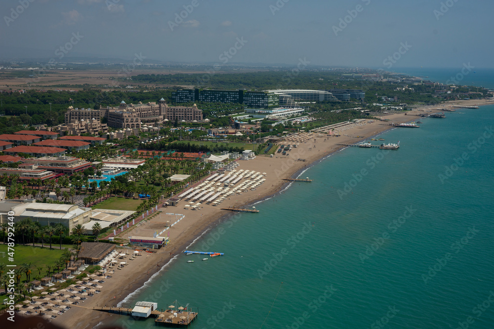 vacation,sea,coast,sand,hotel,structure,building,pier,blue,travel,tourism,sightseeing,leisure,boat,yacht,jet-ski,paraglider,