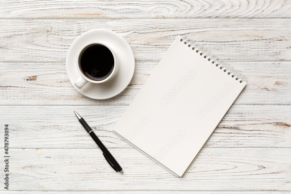 Modern office desk table with notebook and other supplies with cup of coffee. Blank notebook page for you design. Top view, flat lay Modern office desk table with notebook and other supplies with cup of coffee. Blank notebook page for you design. Top view, flat lay