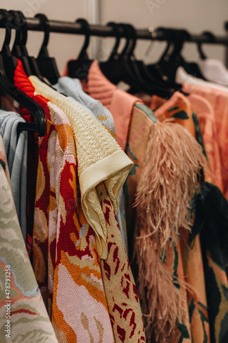 Foto Designer fashion outfits hanging in a row at the backstage