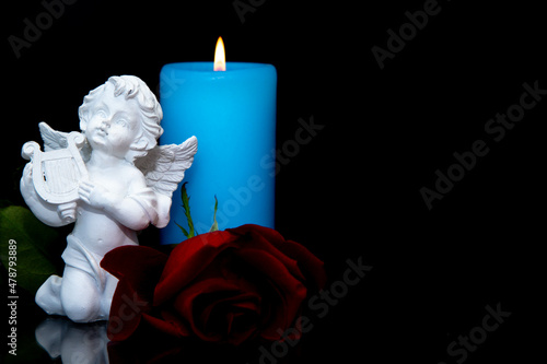 Candle,rose and angel on black background