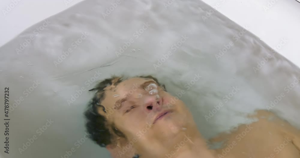Young Man Lies Underwater in the Bath. Depression Concept and Emotional