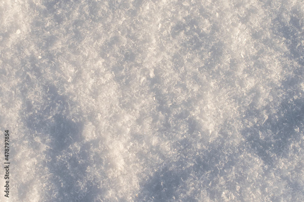 Full frame of winter snowflakes on the ground, top view. Pure white snow texture for background
