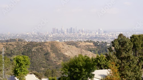 Aerial Slowly Panning Along Trees And Hills With A Hazy Downtown City Skyline In The Distance - Los Angeles, California